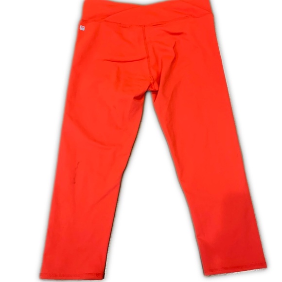 Fabletics Midrise Capris in orange with crossover waistband and hidden pocket - Picture 4 of 8